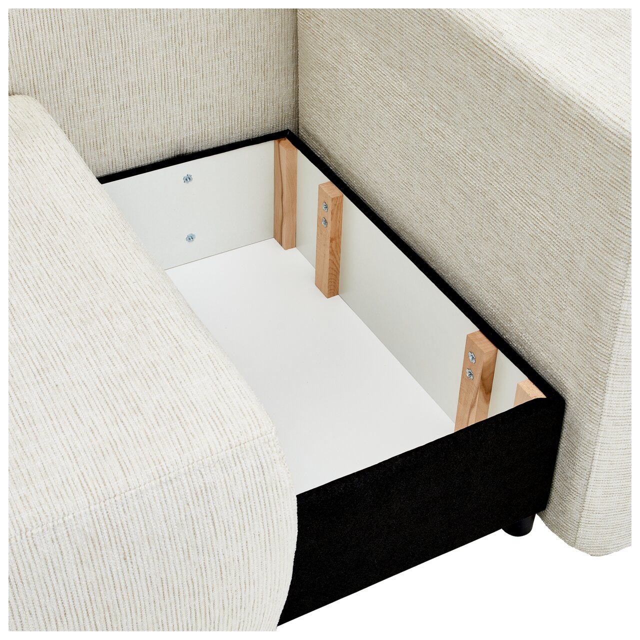 Innenansicht eines Stauraums einer cremefarbenen Recamiere mit Holzverstärkungen, von oben betrachtet.