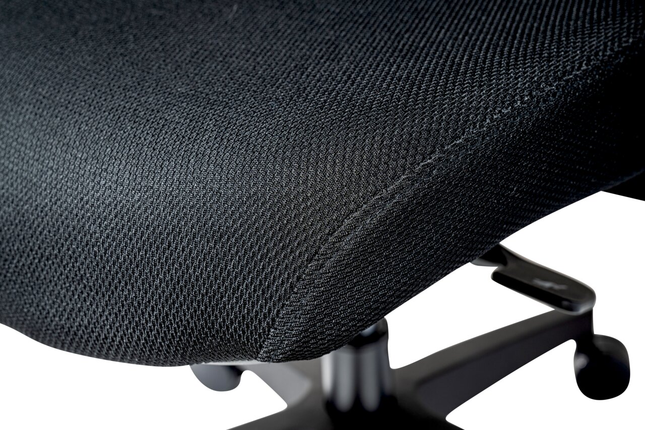 Nahaufnahme eines schwarzen Drehstuhlsitzes mit Textilbezug, seitliche Perspektive