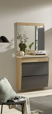 Wandmontierter Schuhschrank in Eiche-Optik mit zwei anthrazitfarbenen Klappen und Schublade, darüber passender Wandspiegel; Szene in schräger Frontansicht im hellen Flur.