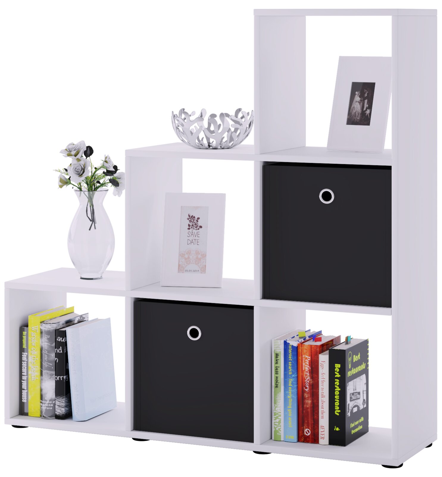 Weißes Stufenregal/Bücherregal mit offenen Fächern und zwei schwarzen Stoffboxen, dekoriert mit Vase, Schale und Bilderrahmen, frontal in leichter Schrägansicht fotografiert.