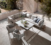 Moderner Gartentisch mit grauen Stühlen und einem Ecksofa in einer stilvollen Terrasse, von oben betrachtet.