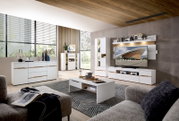 Moderner Couchtisch in Weiß mit Holzdetails, zentral im Wohnzimmer platziert, aus der Perspektive eines Sitzenden auf dem Sofa.