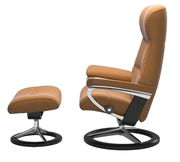 Seitenansicht eines braunen Stressless Einzelsessels PHILIP mit passendem Hocker, beide auf einem eleganten Metallgestell.