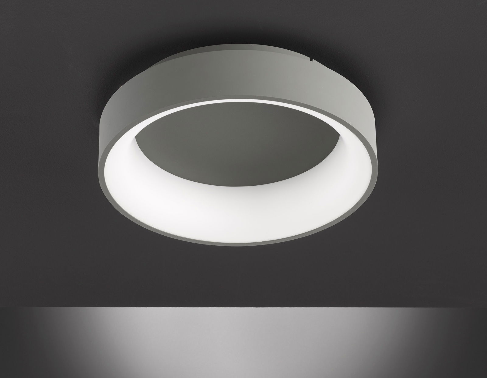 Moderne runde Deckenleuchte in seitlicher Perspektive, mit weißem Leuchtring und grauem Gehäuse.