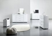 Moderne weiße Hochglanz-Kommoden in einem minimalistischen Raum, fotografiert aus einer seitlichen Perspektive.
