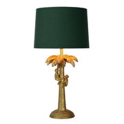 Gouden tafellamp in de vorm van een palmboom met twee apen, met een groene lampenkap, gezien van voren.