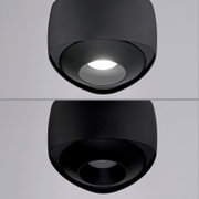 Schwarze, runde LED-Deckenaufbauleuchte mit zylindrischem Gehäuse und tief eingelassener Linse/Reflektor, in leicht schräger Untersicht von unten fotografiert