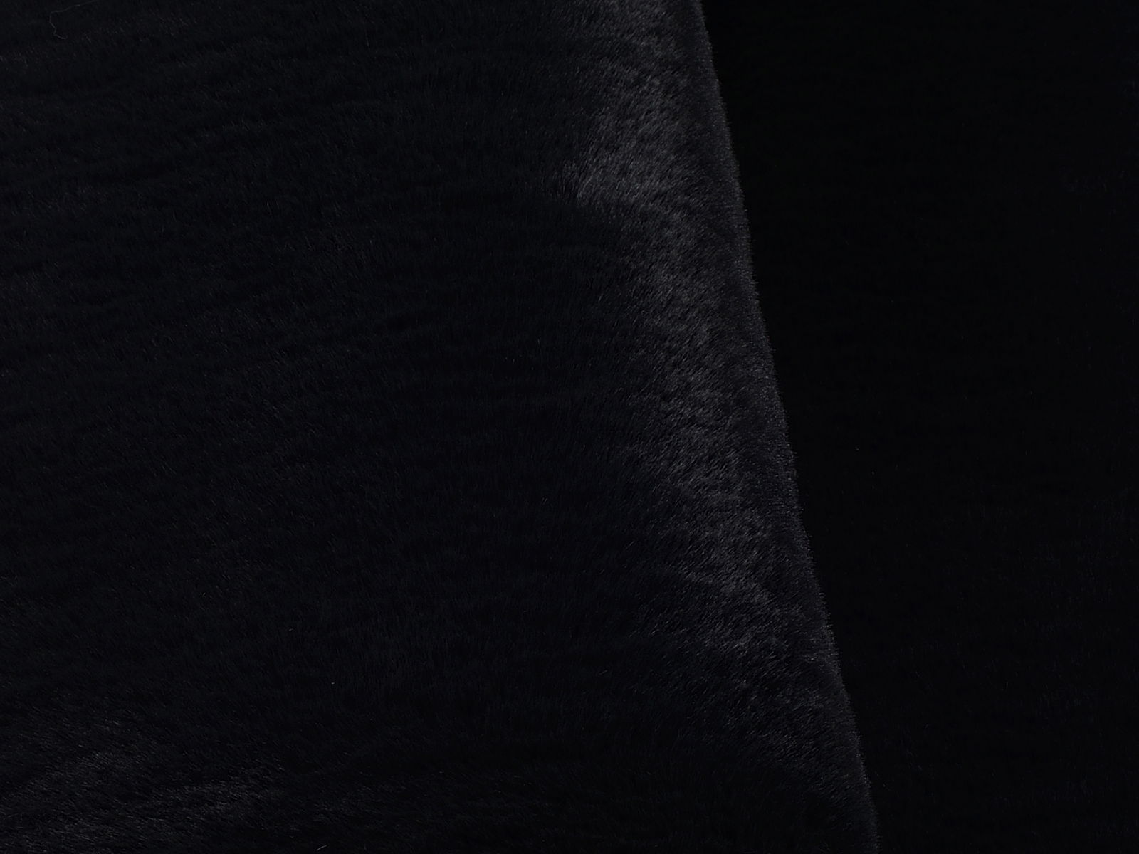 Nahaufnahme eines schwarzen Fellteppichs aus seitlicher Perspektive