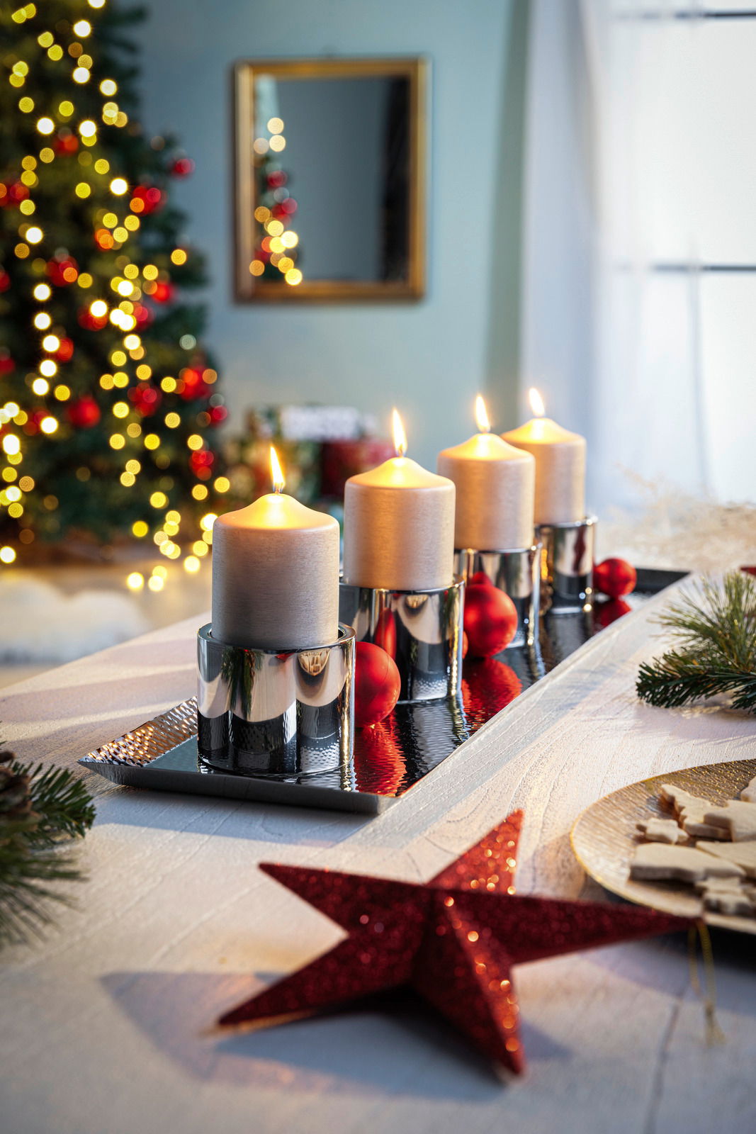 Edelstahl Tablett mit vier brennenden Kerzen und roten Weihnachtskugeln, seitliche Perspektive