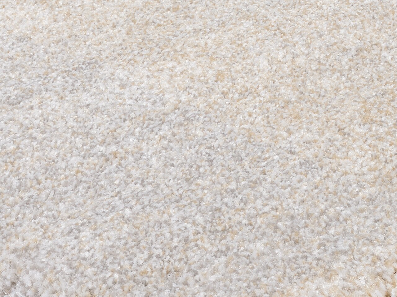 Nahaufnahme eines weichen, cremefarbenen Teppichs mit flauschiger Textur, perspektivisch von oben betrachtet.