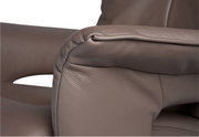 Close-up van een bruine leren fauteuil, met de nadruk op de armleuning.
