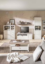 Moderner Couchtisch in heller Holzoptik, zentral im Wohnzimmer platziert, umgeben von stilvollen Möbeln und Dekorationen, aus der Perspektive vom Sofa aus gesehen.