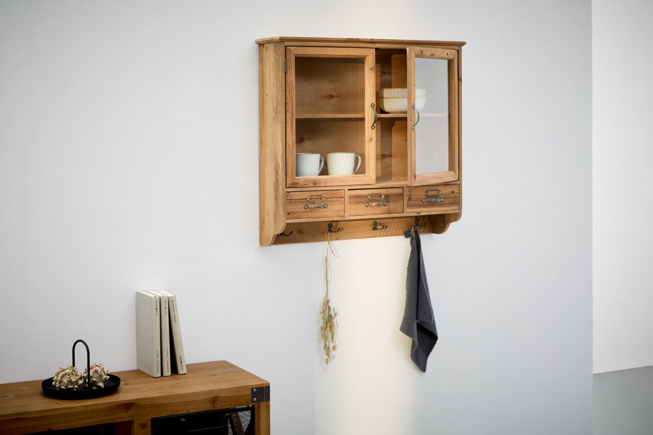 Landscape Hängevitrine KALLE Hängevitrine aus Holz mit Glastüren, seitlicher Perspektive, dekoriert mit Tassen und Schalen.
