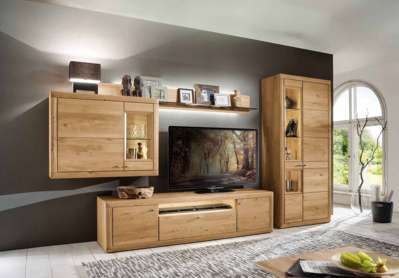 Moderne Wandkombination aus Holz in einem Wohnzimmer, bestehend aus Hängeschrank, TV-Schrank und hohem Schrank, frontal betrachtet.