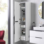 Hochschrank links mit geöffneter Tür, zeigt mehrere Glasregale mit Handtüchern und Pflegeprodukten, seitliche Perspektive