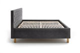 Seitliche Ansicht eines modernen Polsterbetts mit dunklem Stoffbezug und Holzfüßen.