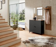 Garderoben-Set in Graphit mit modernem Design, bestehend aus einem Schrank mit zwei Schubladen, einem Spiegel und einer Wandgarderobe mit Ablage. Perspektive: seitliche Ansicht in einem hellen Flur mit Treppe und Glaswand.