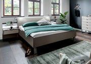 Modernes Futonbett in einem stilvollen Schlafzimmer, seitliche Perspektive mit grüner Bettwäsche und eleganten Nachttischen.