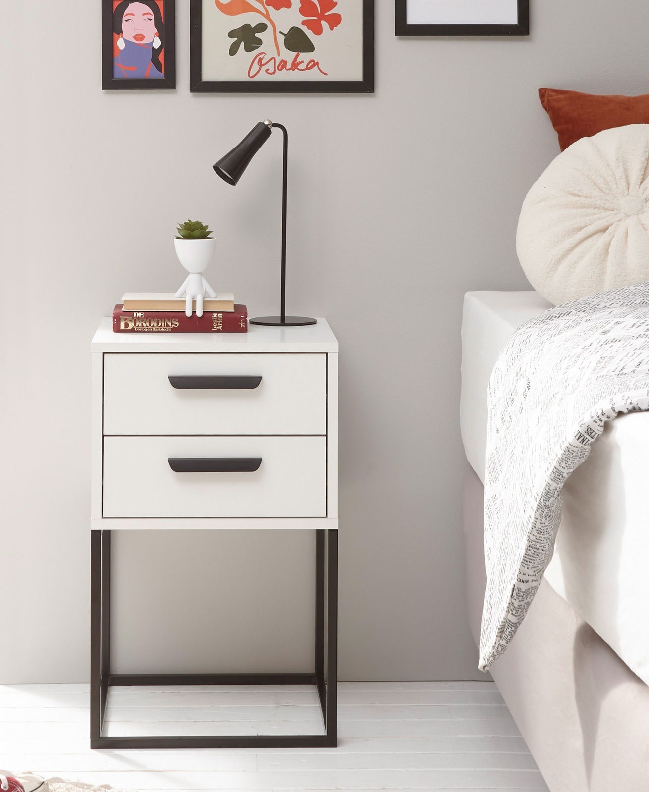 Moderne Nachtkommode mit zwei Schubladen, schwarzem Metallgestell und Dekoration, seitliche Perspektive