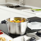 Fissler Vitavit Premium Schnellkochtopf 4,5 l auf einem Herd, gefüllt mit frischem Gemüse, seitliche Perspektive