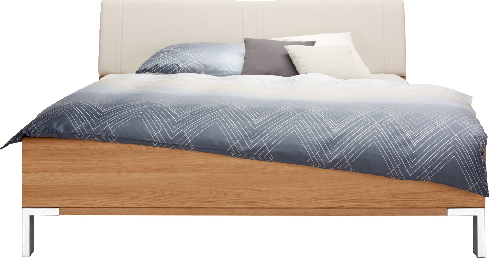 Futonbed met houten frame en gestoffeerd hoofdeinde, gezien vanaf de voorkant, met blauw beddengoed en verschillende kussens.