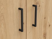 Nahaufnahme von zwei schwarzen Griffen auf einer Holzkommode, frontale Perspektive