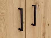 Nahaufnahme von zwei schwarzen Griffen auf einer Holzkommode, frontale Perspektive