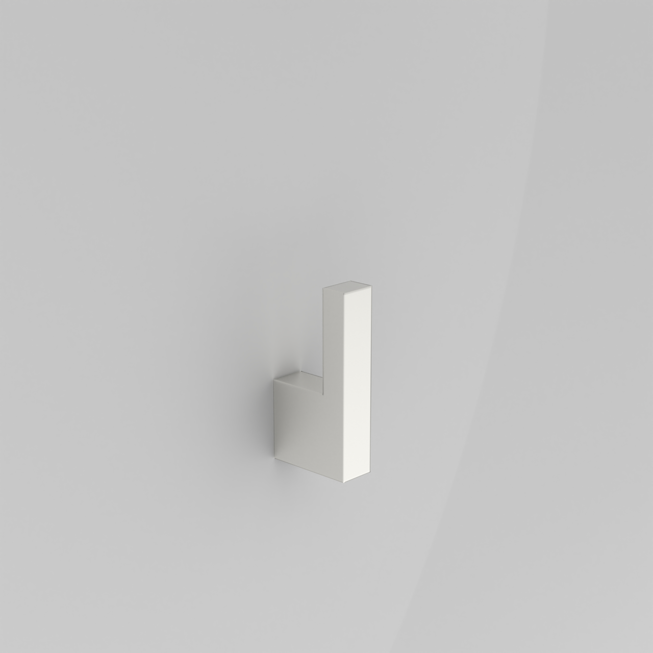 Minimalistischer, weißer Wandhaken in L-Form an einer hellgrauen Wand, schräg von vorne in leichter Seitenansicht fotografiert.