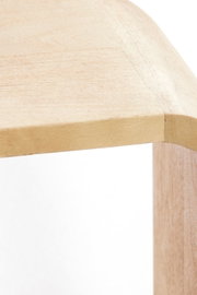 Close-up van een hoek van een houten staande kast van lichtgekleurd hout, gezien van bovenaf.