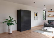 Schwarzer dreitüriger Drehtürenschrank in einem modernen Wohnzimmer, seitliche Perspektive.