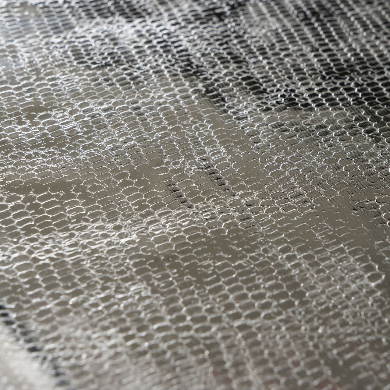 Nahaufnahme eines Tabletts aus Aluminium mit strukturierter Oberfläche, seitliche Perspektive.