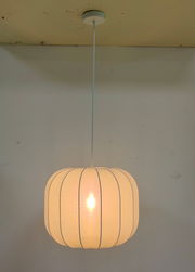 Hängeleuchte mit rundem, textilbespanntem Schirm, von unten fotografiert.