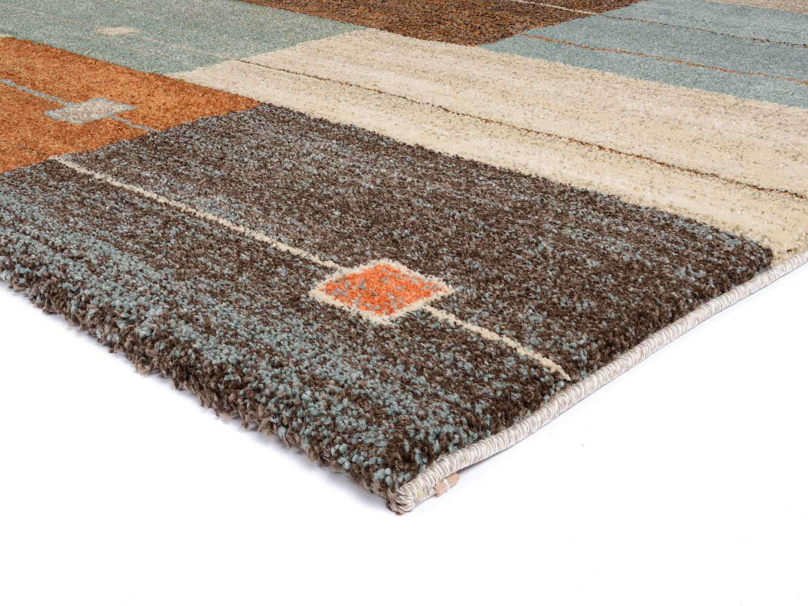 Frisé-Teppich mit geometrischem Muster in Braun-, Beige- und Blautönen, perspektivisch von der Seite fotografiert.