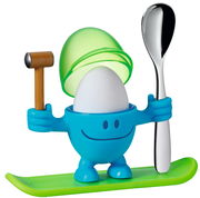 Blauer Eierbecher McEgg mit einem Ei, einem Löffel und einem Hammer, auf einem grünen Sockel stehend, frontal betrachtet.