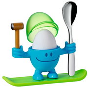 Blauer Eierbecher McEgg mit einem Ei, einem Löffel und einem Hammer, auf einem grünen Sockel stehend, frontal betrachtet.