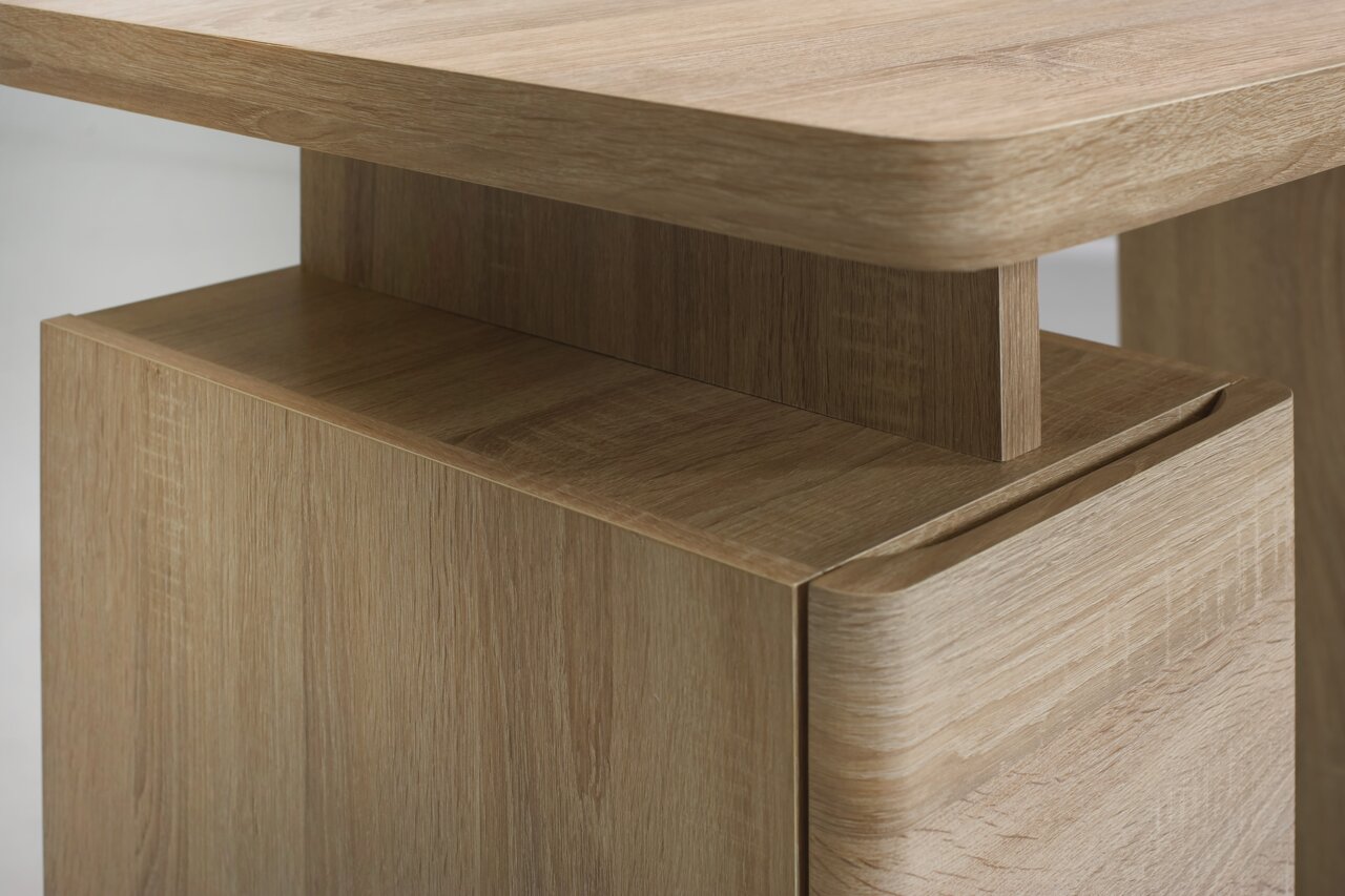 Nahaufnahme eines Schreibtisches aus Holz mit abgerundeten Kanten, seitliche Perspektive