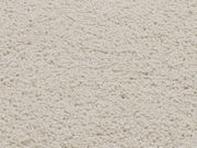 Nahaufnahme eines cremefarbenen Uni-Teppichs mit weicher, flauschiger Textur.