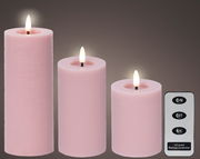 Drei rosa LED-Kerzen in verschiedenen Größen mit flackerndem Licht, begleitet von einer Fernbedienung. Frontalansicht.