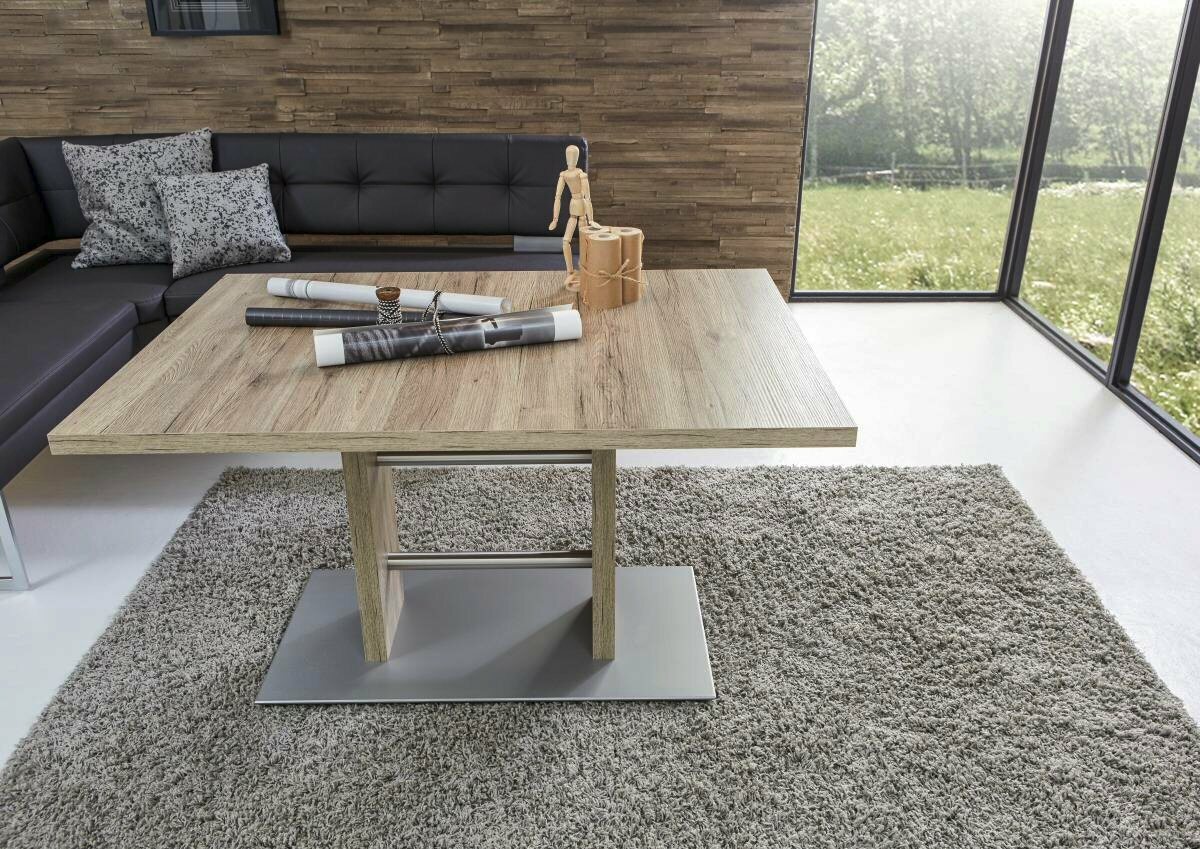 Moderner Esstisch aus Holz mit Metallfuß, umgeben von einem gemütlichen Wohnzimmer mit Ecksofa, aus der Vogelperspektive fotografiert.