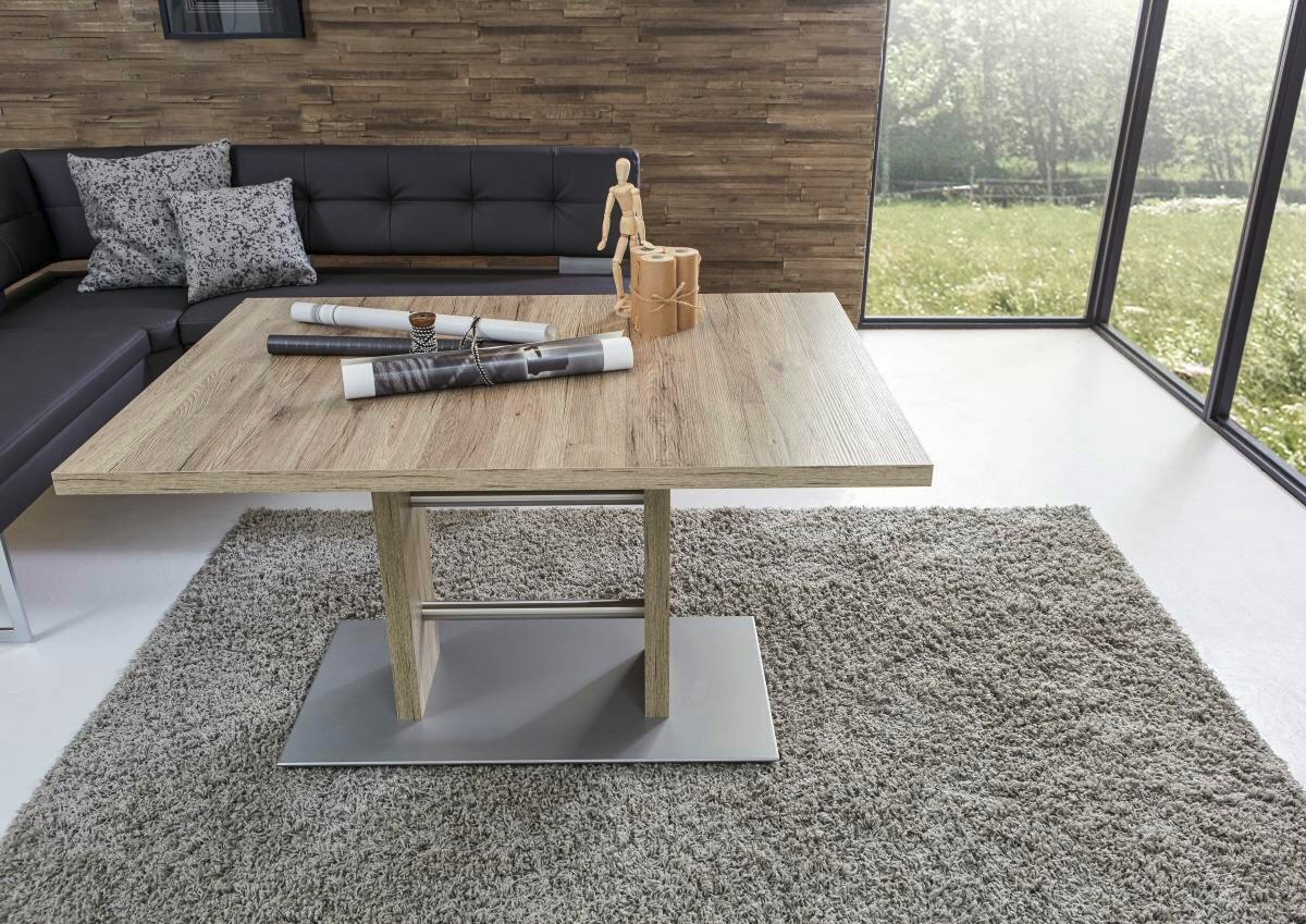 Moderner Esstisch aus Holz mit Metallfuß, umgeben von einem gemütlichen Wohnzimmer mit Ecksofa, aus der Vogelperspektive fotografiert.