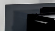 Nahaufnahme eines Elektrokamins von der Seite, die die glatte, dunkle Oberfläche und die Befestigungselemente zeigt.