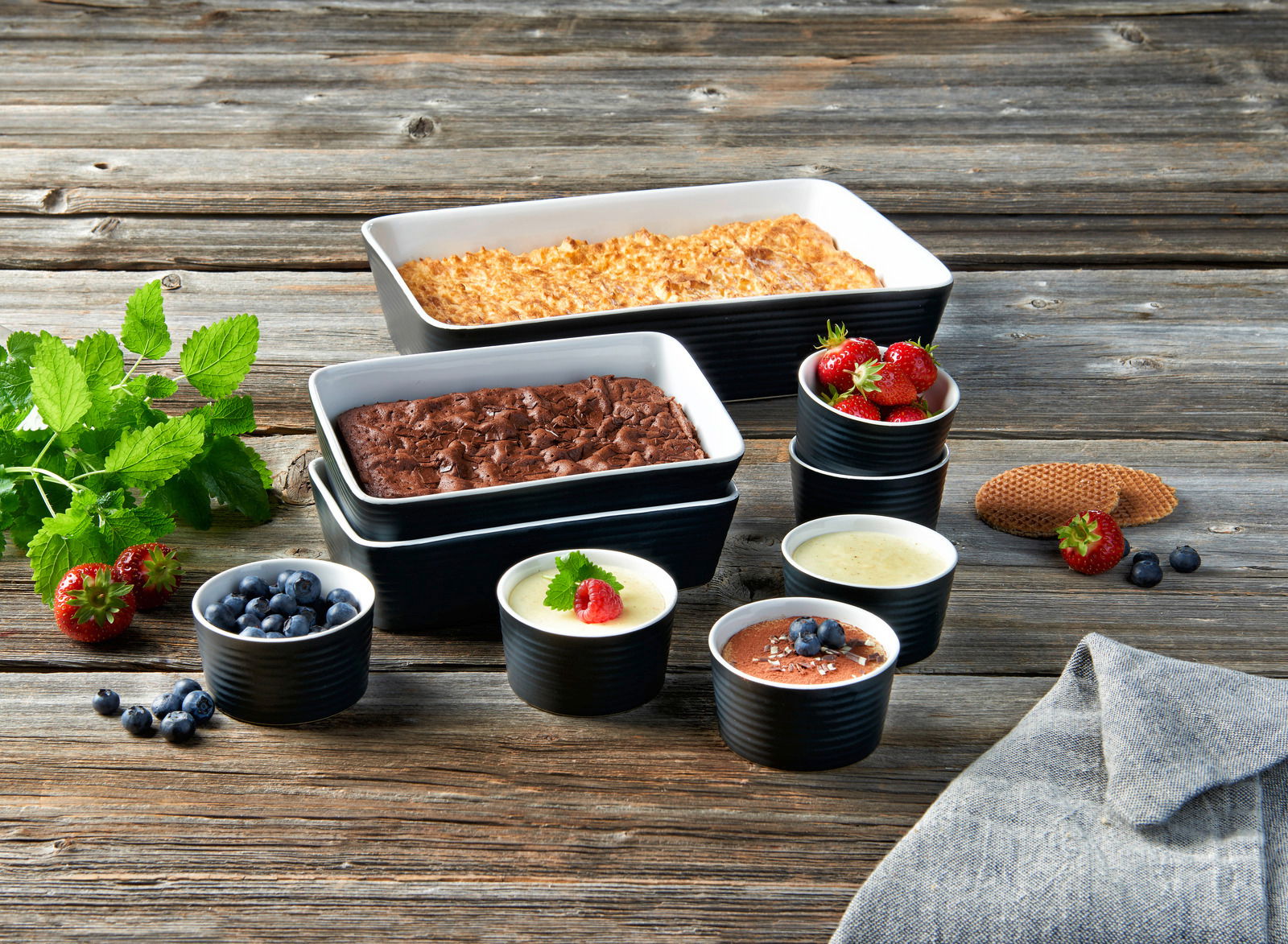 Backformenset 9-tlg. mit verschiedenen Desserts und Früchten, von oben betrachtet auf einem Holztisch arrangiert.