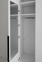 Geöffneter weißer Kleiderschrank mit verspiegelter Tür, Einlegeböden und Kleiderstange, in schräger Nahansicht von vorn
