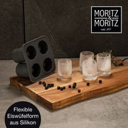 Flexible Eiswürfelform aus Silikon, perspektivisch von der Seite auf einem Holzbrett mit gefrorenen Gläsern und Wacholderbeeren.