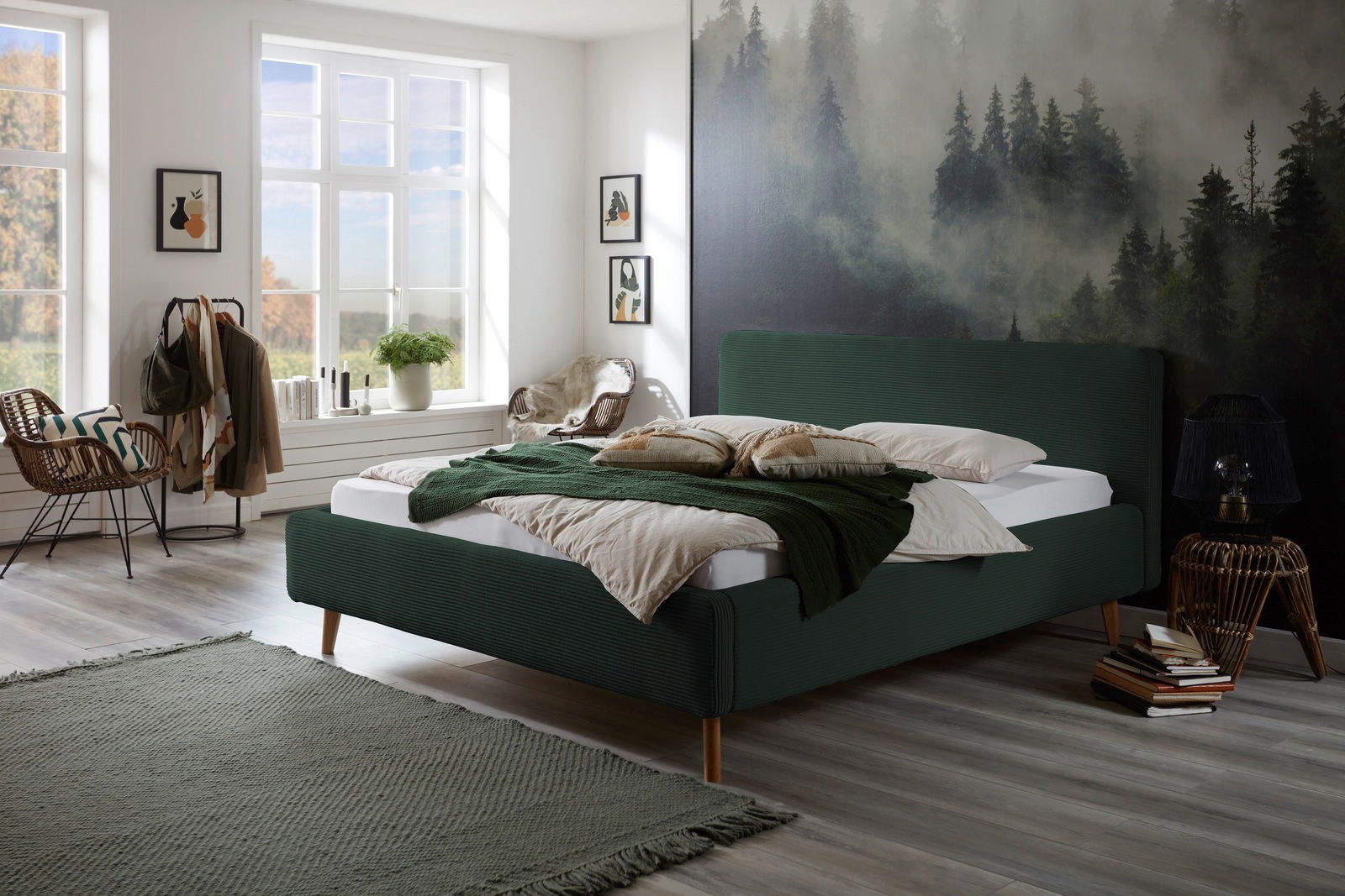 Modernes Polsterbett in einem stilvoll eingerichteten Schlafzimmer mit Waldblick, seitliche Perspektive.