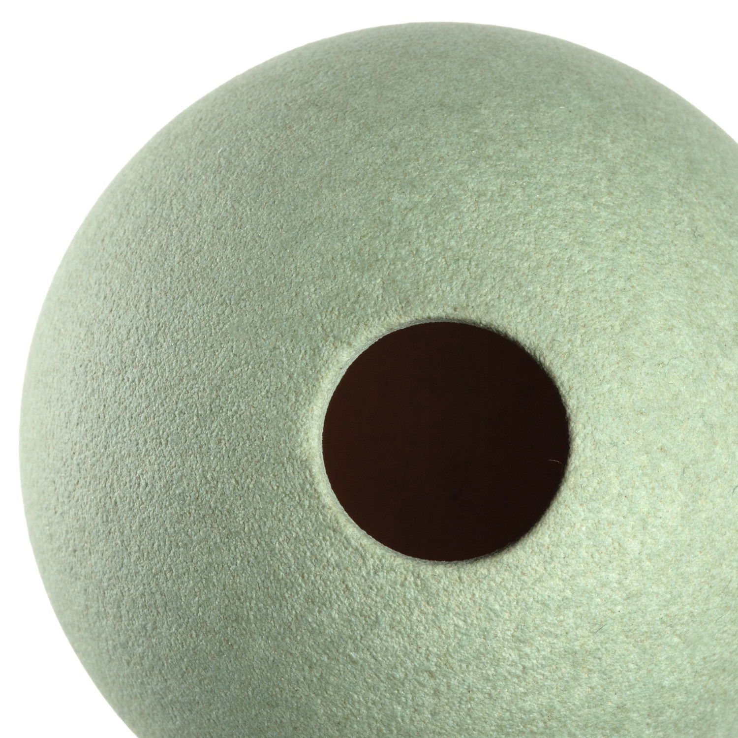 Nahaufnahme einer grünen Keramikvase mit runder Öffnung, von oben betrachtet.