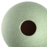 Nahaufnahme einer grünen Keramikvase mit runder Öffnung, von oben betrachtet.