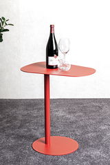 Roter Beistelltisch mit einer Weinflasche und einem Weinglas, seitliche Perspektive