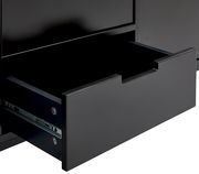 Nahaufnahme eines geöffneten Schubfachs eines schwarzen TV-Lowboards, seitliche Perspektive