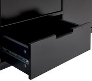 Nahaufnahme eines geöffneten Schubfachs eines schwarzen TV-Lowboards, seitliche Perspektive